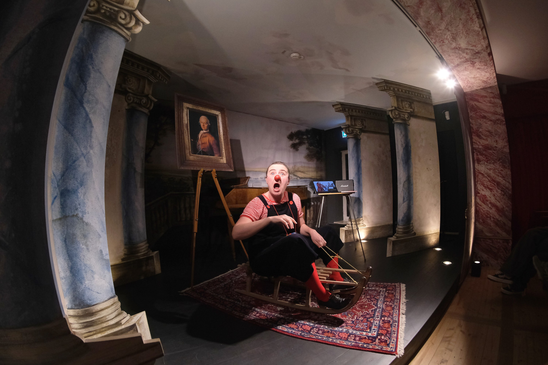 Clown sitzt auf Schlitten in Museum