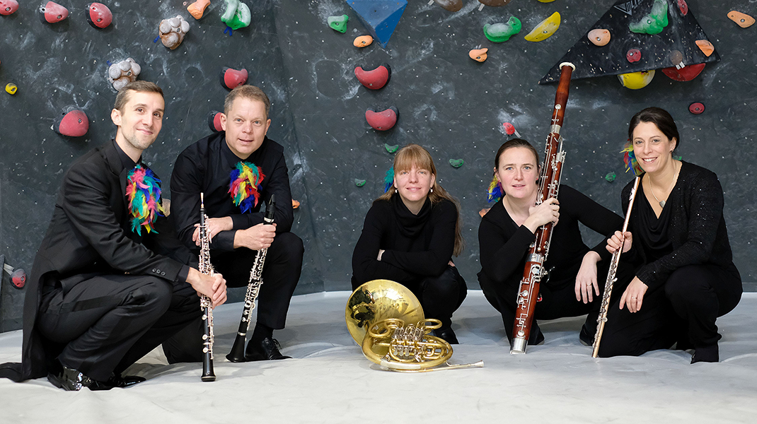 Fünf Musiker vor einer Kletterwand
