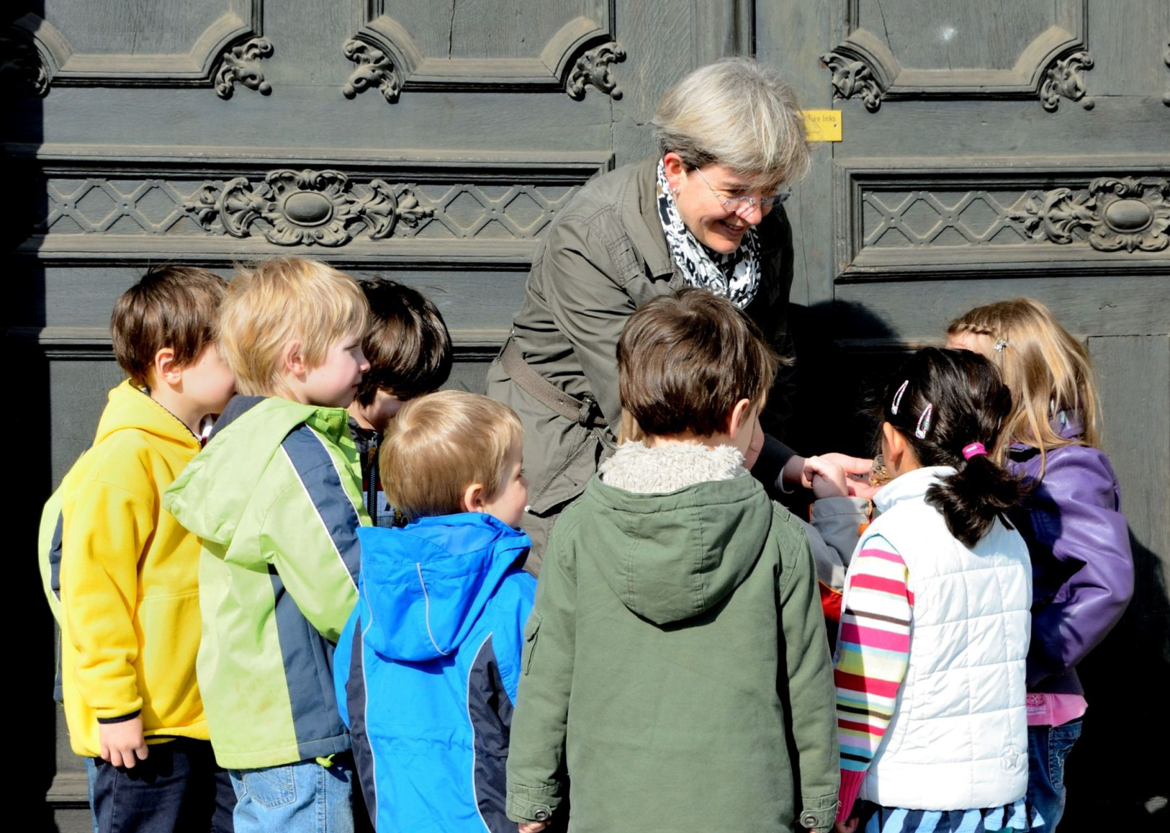 Frau erklärt einer Gruppe von Kindern etwas