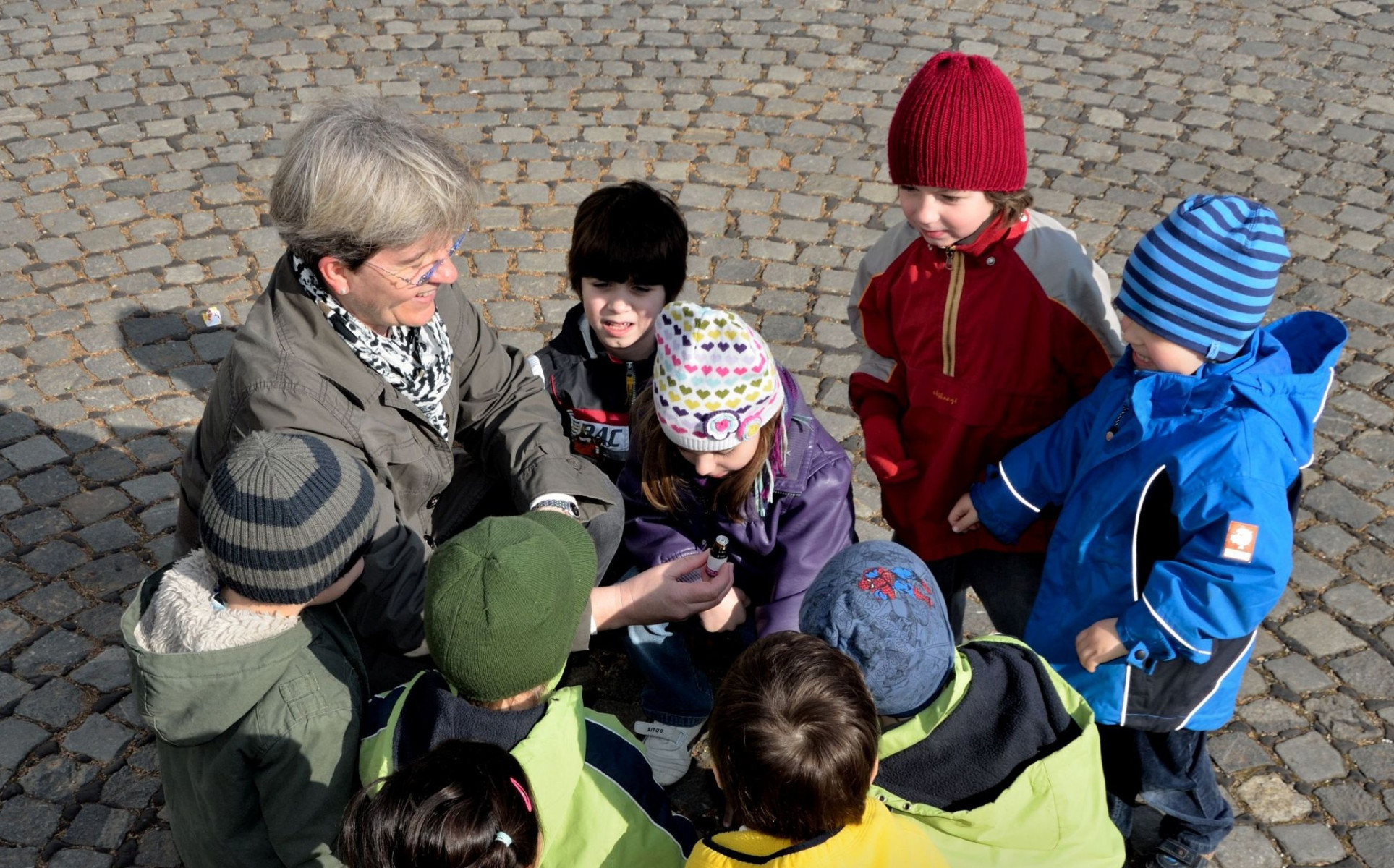 Frau erklärt einer Gruppe von Kindern etwas