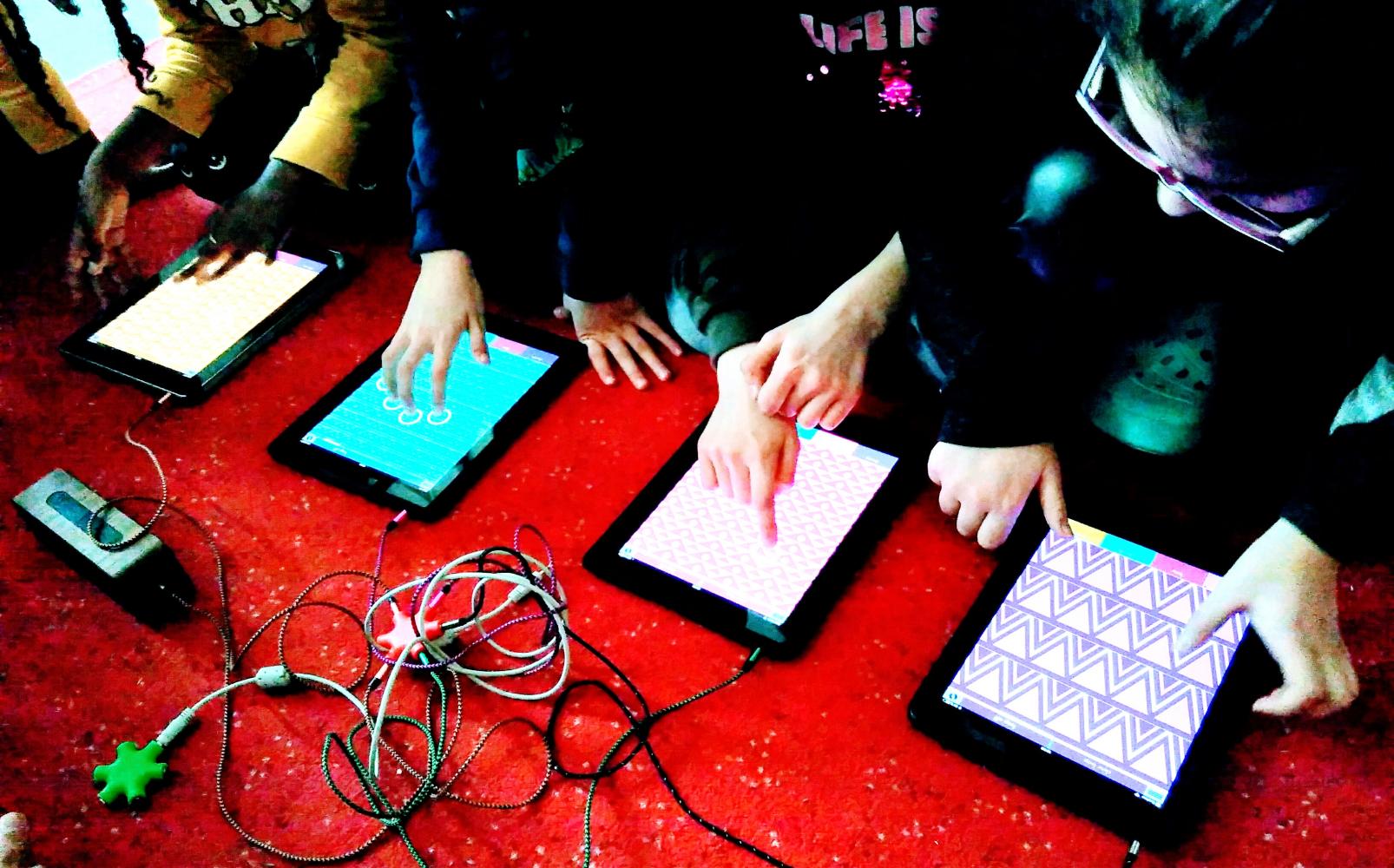 Vier Menschen spielen gemeinsam Musik mit Tabletts