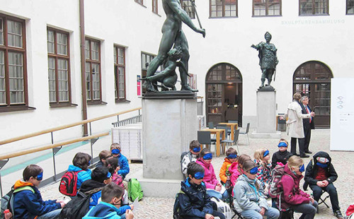 Kinder sitzen mit Augenmasken und lauschen