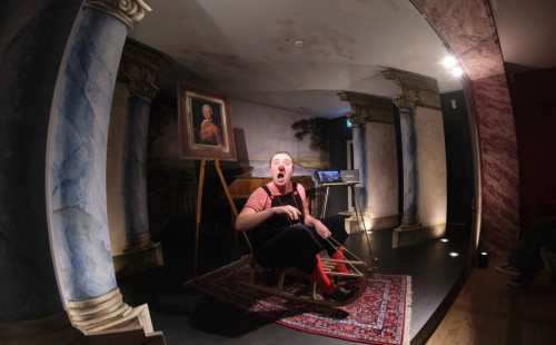 Clown sitzt auf einem Schlitten in einem Museum