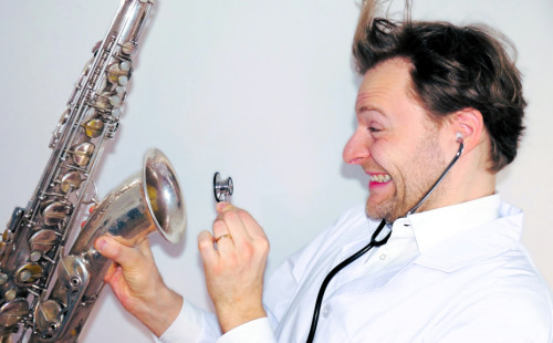 Mann schaut in Saxofon